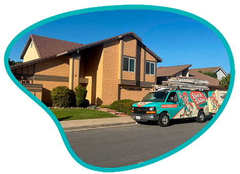 A branded Rock and Rollers Painting company van parked in front of a residential house, ready for exterior painting services.